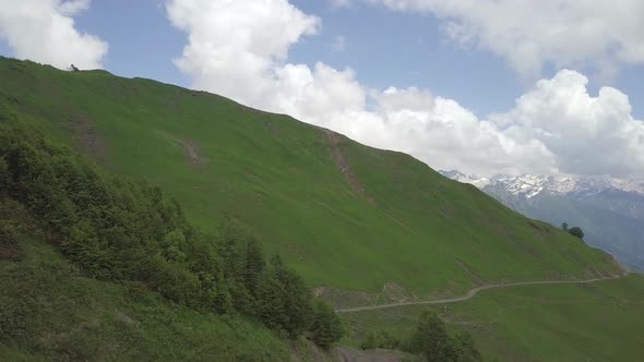 Aerial Shot of Road Under the Hill with Walkers