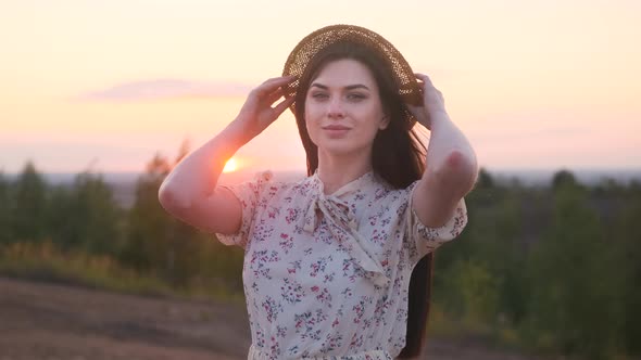 Portrait of Beautiful Attractive Woman in White Dress Fluttering in Wind at Sunset or Dawn Looks