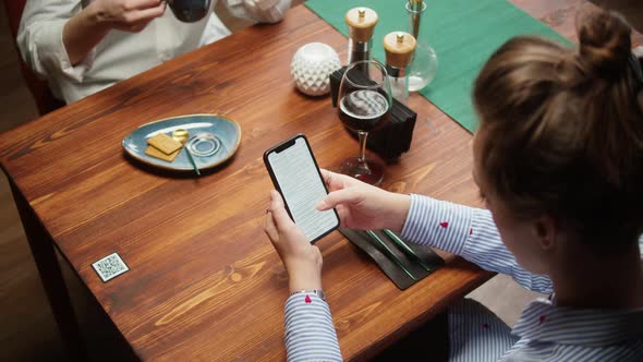 Woman Using Online Menu in Cafe Scanning Qr Code with Smartphone in Restaurant