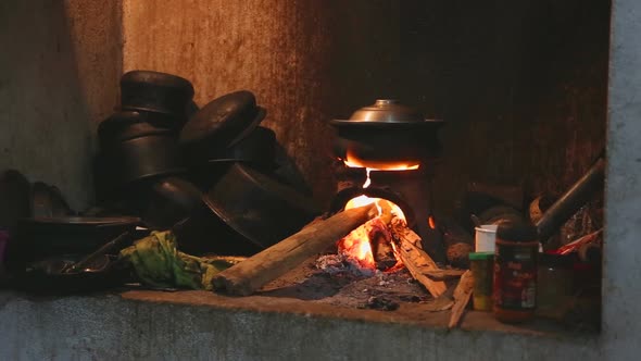 View burning fire heating a pot for cooking in local kitchen in Sri Lanka