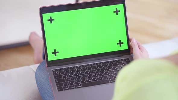 Closeup of Chromakey Green Screen Laptop with Female Caucasian Hand Pressing Keyboard