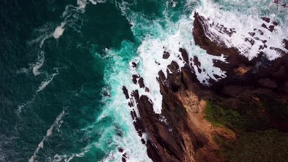 Ocean Waves Crash on Rock Cliff in Big Sur Cali, Wide Overhead Drone Shot