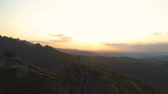 Mountain Hiker with Backpack on Mountain Peak with Breathtaking Hills Panoramic View at Sunset