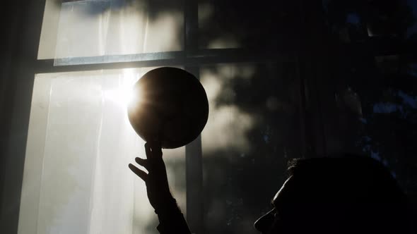 Silhouette of Man Spinning a Soccer Ball on His Finger Closeup of Professional Football Player