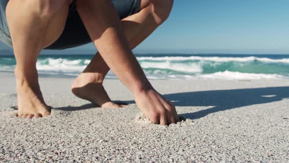 Man crouching on the beach