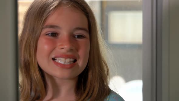 Closeup of the Girl Looking at Her Teeth in the Mirror and Brushing Her Teeth