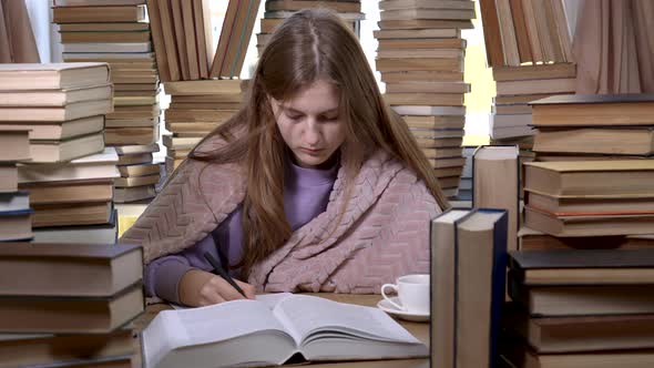 A Girl Reads a Book in the Library