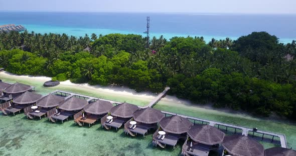 Wide angle flying tourism shot of a sunshine white sandy paradise beach and aqua turquoise water bac