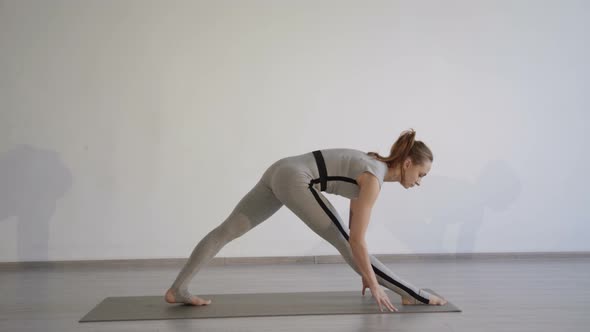 Attractive Sporty Girl Training Legs Stretching in a Calm Comfortable Studio.