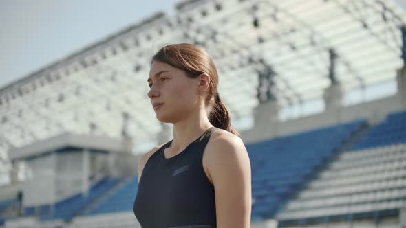 Side View of a Group Female Athlete Starting Her Sprint on a Running Track. Runner Taking Off From