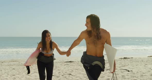 Couple with surfboard walking on the beach 4K 4k