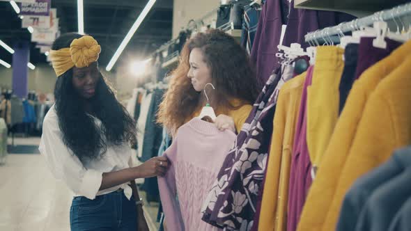 Smiling Ladies Are Picking Clothes While Shopping