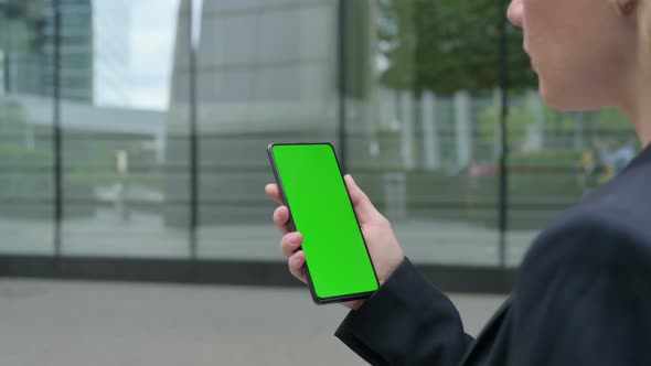 Rear View of Businesswoman Using Smartphone with Green Chroma Screen