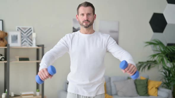 Athletic Man Working Out with Dumbbells at Home