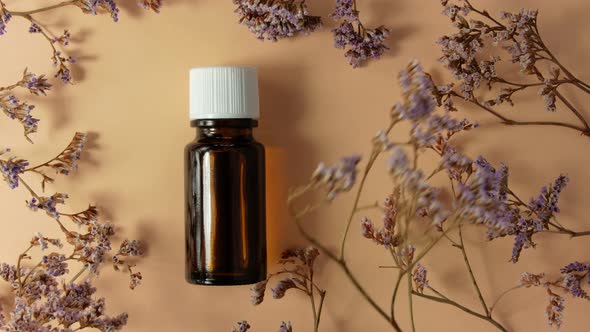 Herbal essential oil glass bottle mockup beige flowers background Spa aromatherapy beauty cosmetics