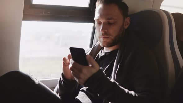 Happy Relaxed European Freelance Worker Using Smartphone Messenger App