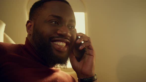 African American Talking Cellphone at Airplane Window Closeup