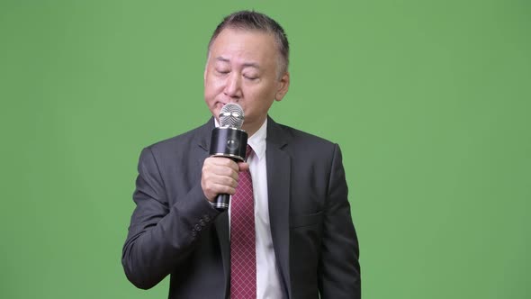 Mature Japanese Businessman Using Microphone