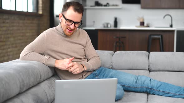 Happy Fit Young Bearded Hipster Man in Glasses Has Video Call