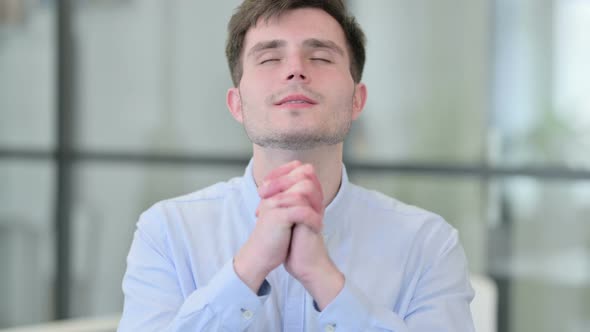 Young Man Praying with Eyes Closed