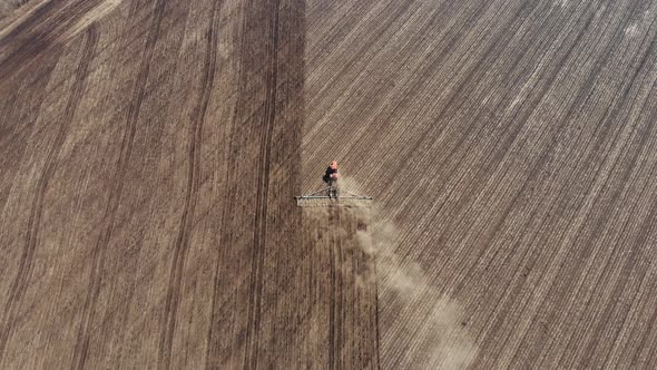 Aerial Footage Modern Red Tractor on the Agricultural Field on Sunny Day. Tractor Plowing Land