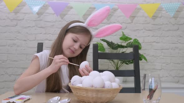 Child Girl Wearing Bunny Rabbit Ears Painting Eggs for Easter