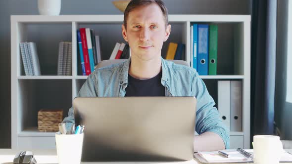 Young male entrepreneur works at home office at the computer.