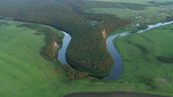 Aerial View of the River with a Rock and Forest on the Banks