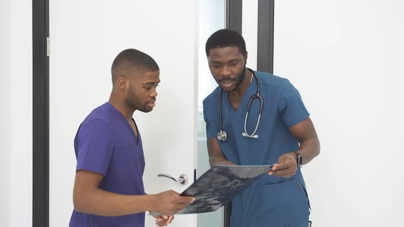 Young Doctors Looking At Computed Tomography Xray Image Discussing