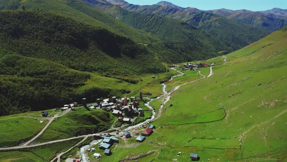 Aerial View of a Mountain Village Along the River in the Middle of a Sunny Summer Day