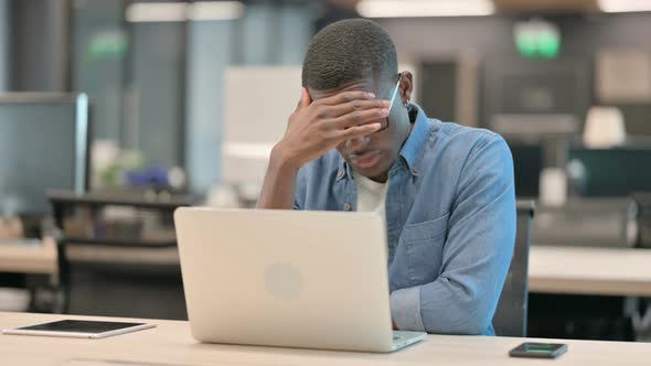 Young African American Man Feeling Tired at Work