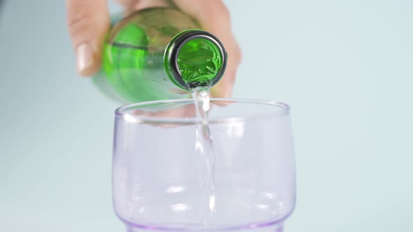 Natural mineral water bottle pouring into glass.