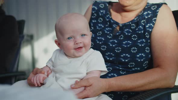 Baby Girl Smiling On Her Grandmother's Lap