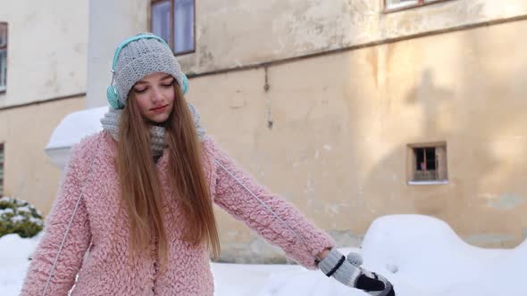 Young Woman Traveler Walking Through the City Street and Listening Positive Music Songs Podcast