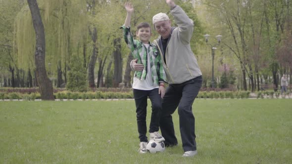 The Little Boy in a Checkered Shirt and Positive Old Man Waving Their Hands