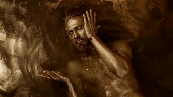 Brawny Sexy Man is Lying in Golden Water Spiritual Practice of Fairytale and Mythical God