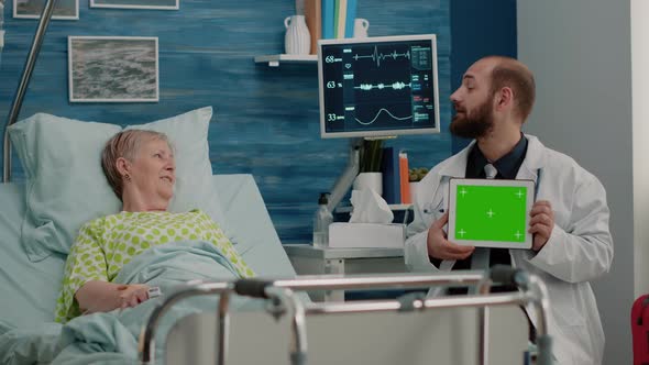 Doctor with Horizontal Green Screen on Tablet Talking to Patient