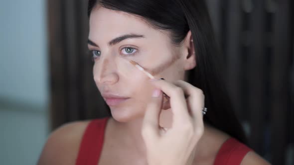 Makeup Artists Apply Highlighter To Raised Areas of Beautiful Young Womans Face