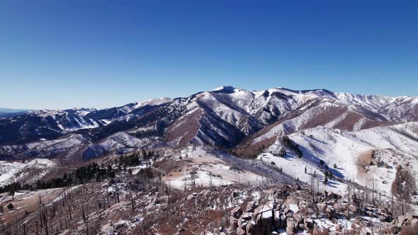 High elevation drone shot of a large snowy mountain peak in New Mexico