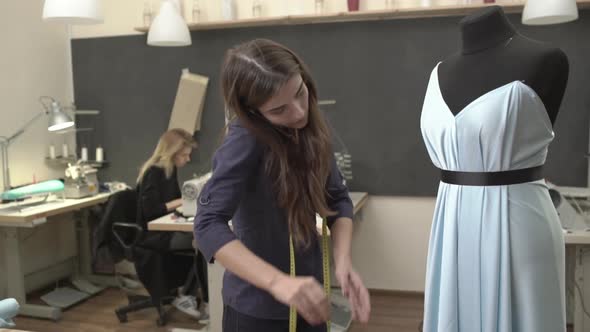 Attractive Caucasian Female with Long Brown Hair and Dark Blue Shirt Standing Near Mannequin with