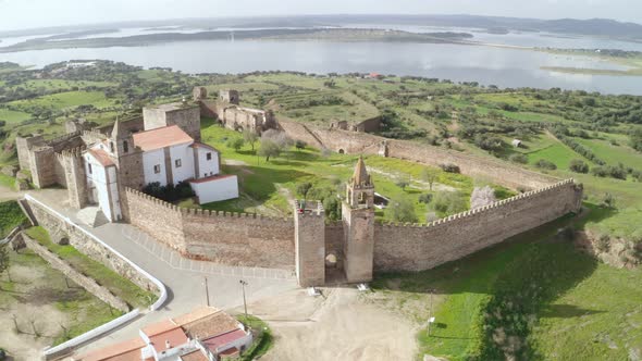 Aerial drone view of Mourao castle with alqueva dam lake behind