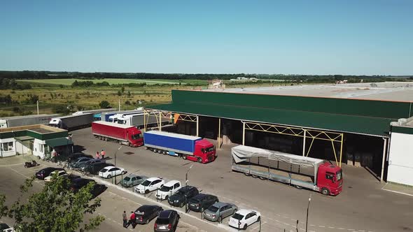 Aerial view of a big factory and a parking lot in the front.