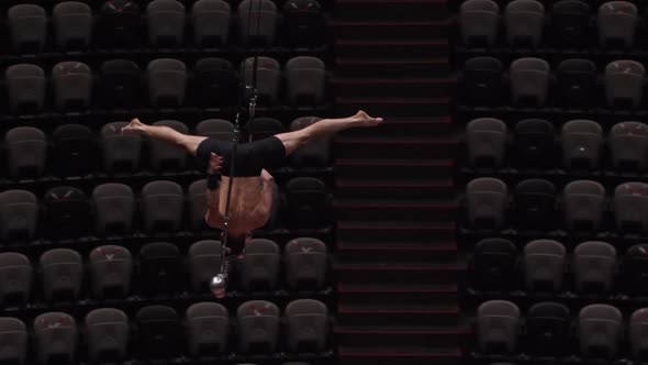 An Acrobatic Man Doing a Show on the Flying Construction  Standing Upside Down Without the Support