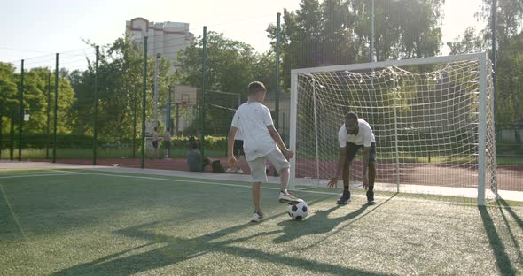 Sportive Man Playing Football with Preteen Boy