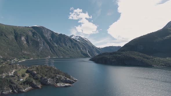 High voltage power lines crossing across fjord in Valldal in Norway, aerial view
