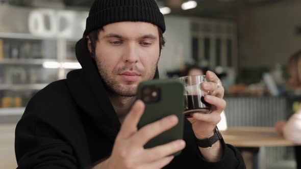 Relaxed Guy Sitting at Cafe Table with Mobile and Coffee