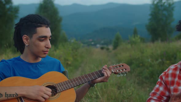 Handsome Hipster Multiethnic Male Tourists Playing Acoustic Guitar and Djembe Drum in Mountains