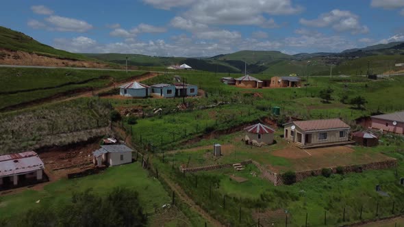 Drone shot of the Transkei in South Africa - drone is flying up a hill full of traditional houses. S