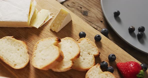 Video of slices of baguette, bluberries and cheese on a wooden surface