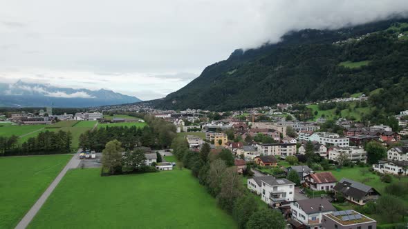 Liechtenstein with Houses on Green Fields in Alps Mountain Valley Aerial View